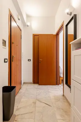 a hallway with two wooden doors and a tile floor at Modern apartment in Portuense in Rome