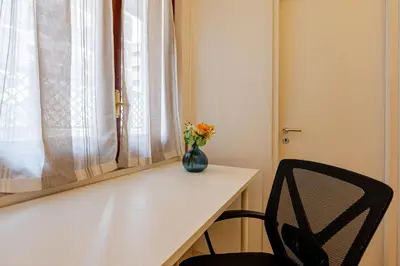 a vase of flowers sitting on a table next to a window at Modern apartment in Portuense in Rome