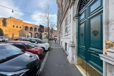 a street with cars parked on the side of a building at La Casa dei Sogni Roma in Rome