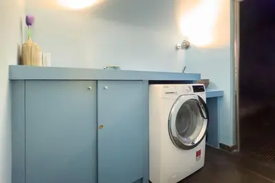 a washing machine under a blue counter in a room at La Casa dei Sogni Roma in Rome