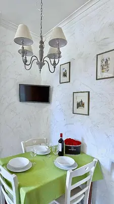 a dining room table with a green tablecloth and white chairs at Sonia Monteverde Apartment per 4 in Rome