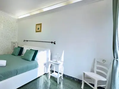 a white bedroom with a bed and a chair at Sonia Monteverde Apartment per 4 in Rome