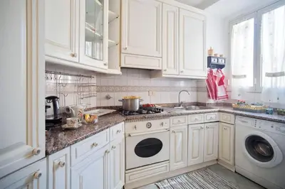a kitchen with white cabinets and a washer and dryer at Sonia Monteverde Apartment per 4 in Rome