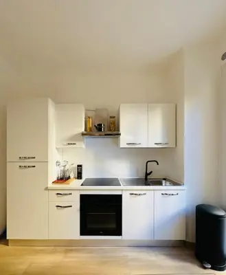 a white kitchen with white cabinets and a sink at Al No60 in Rome
