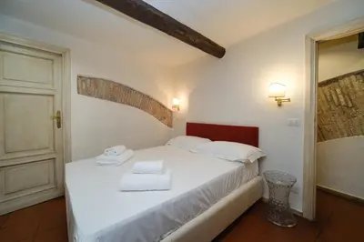 a bedroom with a white bed with towels on it at Pantheon's Arch by BuddyRent in Rome