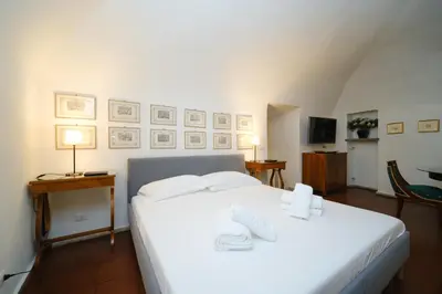 a bedroom with a white bed with two shoes on it at Pantheon's Arch by BuddyRent in Rome