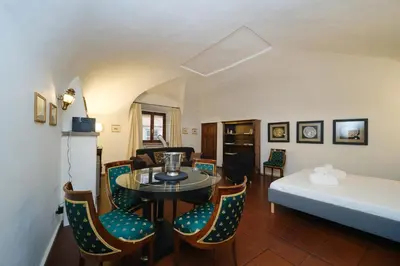 a room with a table and chairs and a bed at Pantheon's Arch by BuddyRent in Rome