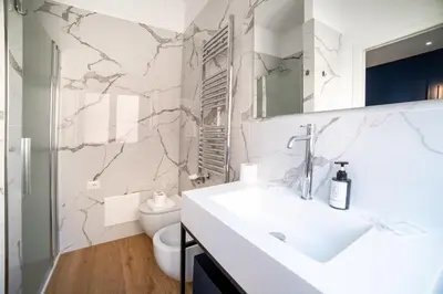 a white bathroom with a sink and a toilet at Barigelli Apartment in Rome