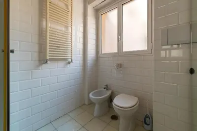 a white bathroom with a toilet and a window at Cappellari 4 - FromHometoRome in Rome