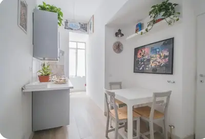 a white kitchen with a white table and chairs at Green House in Rome