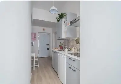 a white kitchen with white cabinets and a sink at Green House in Rome