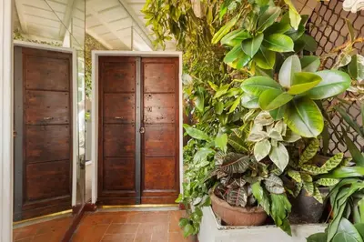 a hallway with two wooden doors and lots of plants at Casa Garibaldi, a Burghesius home in Rome