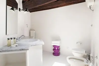 a white bathroom with a sink and a toilet at Casa Garibaldi, a Burghesius home in Rome