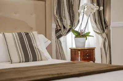 a bedroom with a bed and a vase of flowers on a table at La Residenza del Sole al Pantheon in Rome