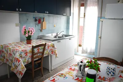 a kitchen with a table and a sink and a table with flowers at A Casa di Lilly in Rome