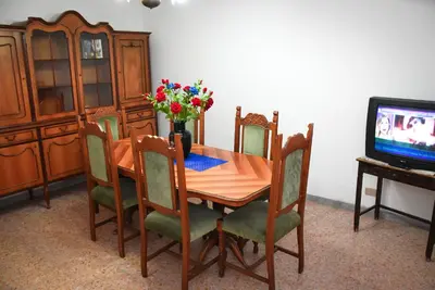 a dining room table with a vase of flowers and a tv at A Casa di Lilly in Rome