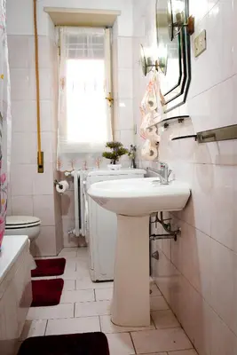 a white bathroom with a sink and a toilet at A Casa di Lilly in Rome