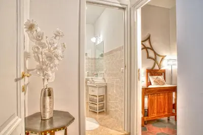 a vase of flowers on a table in a bathroom at Romance al Colosseo in Rome