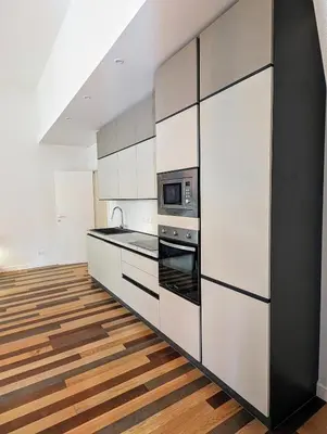 a kitchen with white cabinets and a microwave at Luxury Gallery Suites in Rome