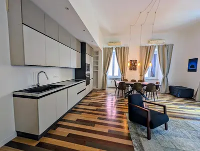 a kitchen with white cabinets and a table with chairs at Luxury Gallery Suites in Rome