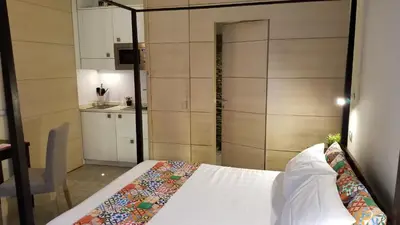 a bedroom with a white bed and a kitchen at HomeFlat in Rome