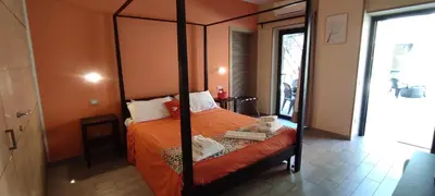 a bedroom with a four poster bed with orange sheets at HomeFlat in Rome