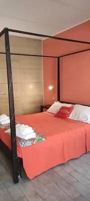a bedroom with a bed with an orange bedspread at HomeFlat in Rome