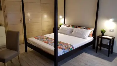 a bedroom with a bed and a chair in a room at HomeFlat in Rome