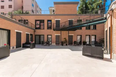 an empty courtyard of a building with tables and chairs at HomeFlat in Rome