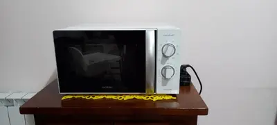 a microwave sitting on top of a wooden table at ary's house in Rome