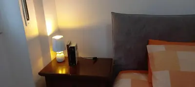 a bedroom with a bed and a nightstand with a lamp at ary's house in Rome