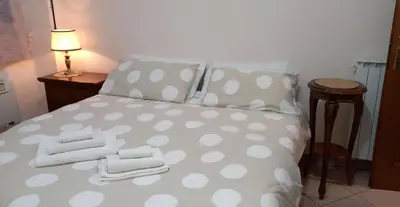 a bed with polka dot sheets and towels on it at ary's house in Rome
