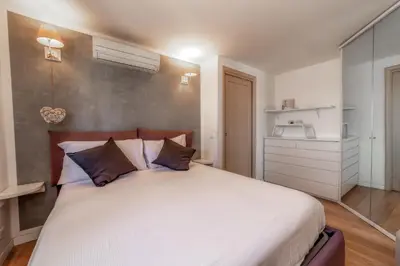 a bedroom with a large white bed with pillows at Cozy Penthouse with Terrace and Rome View in Rome