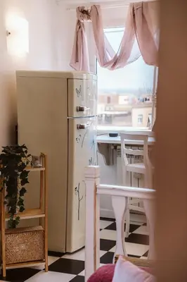 a small kitchen with a refrigerator and a window at Cozy Penthouse with Terrace and Rome View in Rome