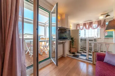 a living room with a kitchen and a dining room at Cozy Penthouse with Terrace and Rome View in Rome