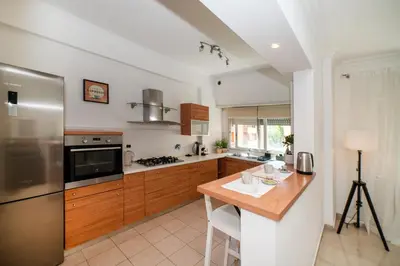 a kitchen with wooden cabinets and a wooden counter top at Bernadette Apartment - Vaticano area in Rome