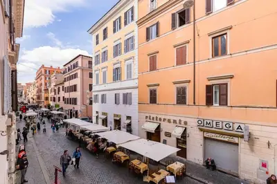 a group of people walking down a street next to buildings at Minisuite a Borgo Pio 