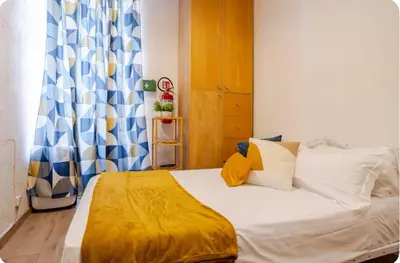 a bedroom with a bed with a yellow blanket on it at Minisuite a Borgo Pio 