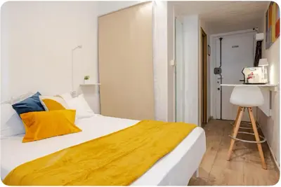 a bedroom with a large bed with a yellow blanket at Minisuite a Borgo Pio 