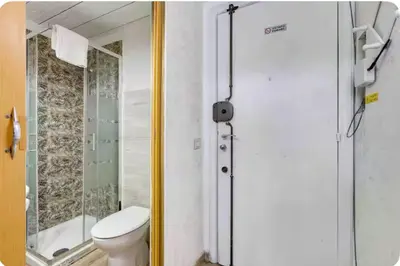 a bathroom with a toilet and a glass shower at Minisuite a Borgo Pio 
