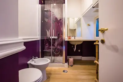 a purple bathroom with a toilet and a sink at Hold Rome - Luxury Suites in Rome