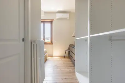 a room with a hallway with white cabinets and a wooden floor at La Dolce Vita - Trastevere Station in Rome