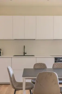 a table and chairs in a kitchen with white cabinets at La Dolce Vita - Trastevere Station in Rome