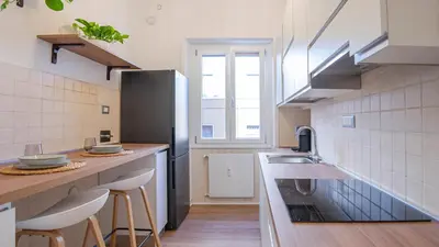 a kitchen with a sink and a counter with stools at Casa Bonnet - Elegant Stay near Trastevere & Gianicolo in Rome
