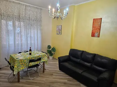a living room with a black leather couch and a table at Mary House in Rome