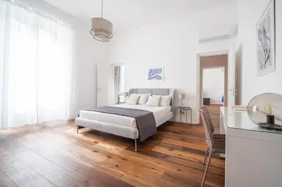 a white bedroom with a bed and a table at Luxury apartment with Vatican views in Rome