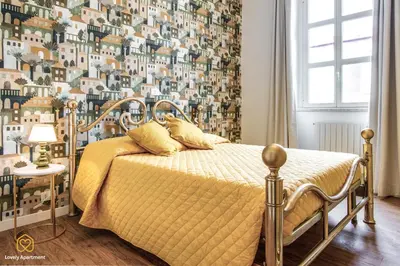 a bedroom with a bed with a yellow comforter at Lovely Apartment in Rome - Volturno in Rome