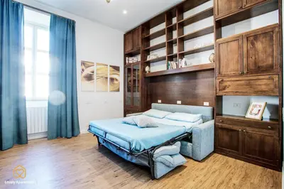 a bedroom with a blue bed and wooden cabinets at Lovely Apartment in Rome - Volturno in Rome