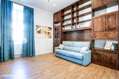 a living room with a blue couch and wooden cabinets at Lovely Apartment in Rome - Volturno in Rome