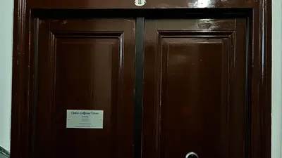 two brown wooden doors with a sign on them at Centro Solferino Rooms in Rome